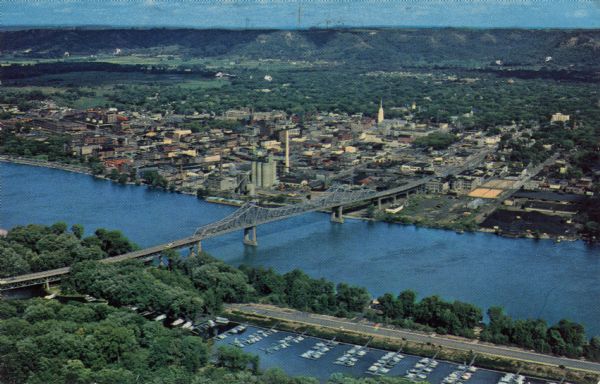 Photographic postcard of an aerial view over La Crosse and the I-90 Interstate bridge. French Island is in the foreground.