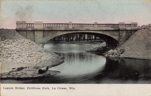 Hand-colored view of the arched stone bridge over the lagoon. Caption reads: "Lagoon Bridge, Pettibone Park, La Crosse, Wis."