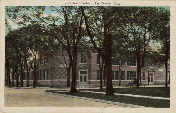 View across street towards the Vocational School, with a Model T parked in front. Caption reads: "Vocational School, La Crosse, Wis."