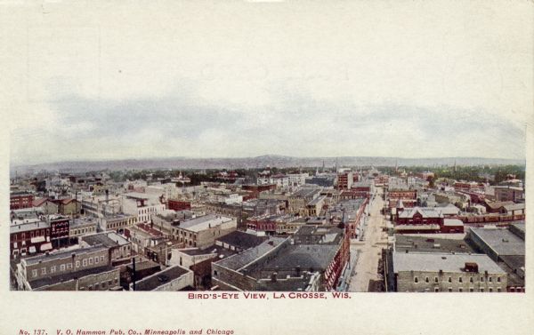 Hand-colored bird's-eye view of La Crosse looking toward the river across the rooftops of commercial buildings and a few churches. Caption reads: "Bird's-Eye View, La Crosse, Wis."