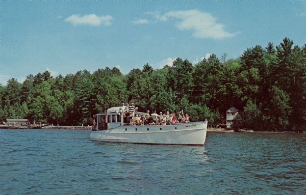 Text on reverse reads: "Chateau Madeleine La Pointe, Wisconsin
Summer and Fall Resort on Madeline Island (Apostle Islands) in Lake Superior. The Chateau's 40 foot cruiser, Invader II, sets forth with its usual load of happy guests."