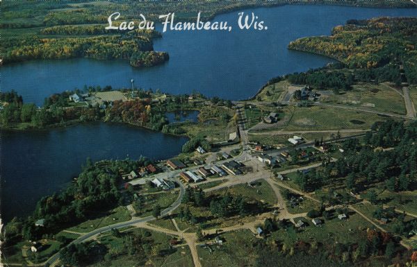 Aerial postcard of Lac du Flambeau village and surrounding lakes. Caption reads: "Lac du Flambeau, Wis." Text on reverse reads: "On State Hwy 47 between Pokegama Lake and Long Intericken Lake, in the heart of the Indian Reservation. A favorite vacation area and numerous resorts here offer excellent accommodations. Indian dances is the major outdoor attraction here throughout the summer plus numerous other festivities."