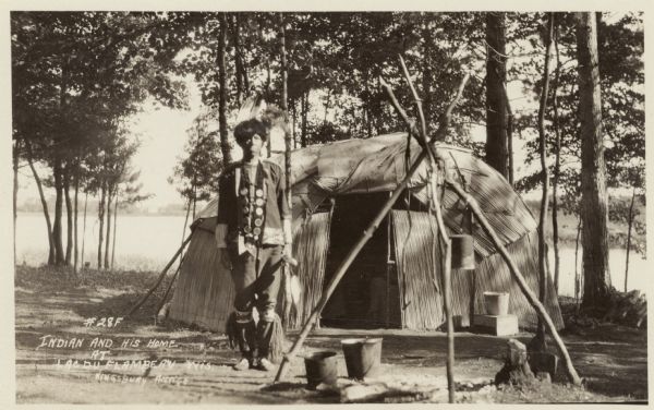 An Ojibwa man and his wigwam near a lake. Caption reads: "Indian and His Home at Lac Du Flambeau, Wis. Kingsbury, Antigo."