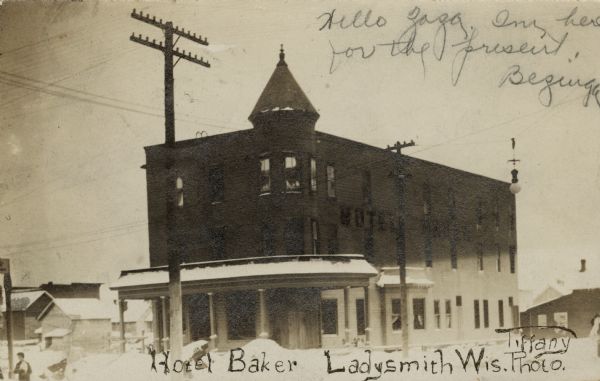 View of a three-story corner hotel with a turret. Caption reads: "Hotel Baker, Ladysmith, Wis." 