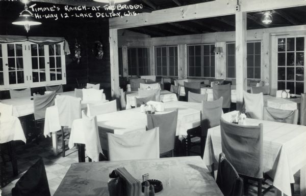 Interior view of the dining room at Timme's Ranch. Caption reads: "Timme's Ranch &#8212; at the Bridge Hi-Way 12 — Lake Delton, Wis."
