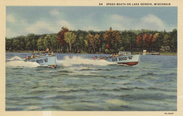 Colorized postcard view across water towards two speed boats on Lake Geneva. The trees are in fall color along the shoreline. The name on the speedboats reads: "Gar Wood '40'." Caption reads: "Speed Boats on Lake Geneva, Wisconsin."