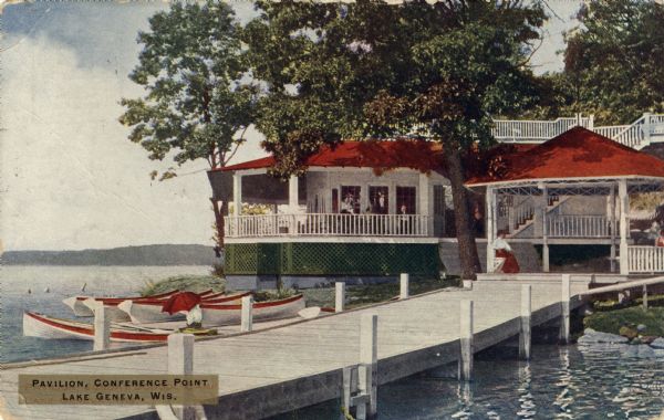 View of a pavilion, and a pier in the foreground. Rowboats are docked at the shoreline. Caption reads: "Pavilion, Conference Point, Lake Geneva, Wis."