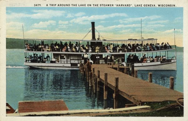 View from shoreline towards an excursion boat at the end of a pier filled with tourists. A boy is fishing on the pier. Caption reads: "A Trip Around the Lake on the Steamer 'Harvard', Lake Geneva, Wisconsin."