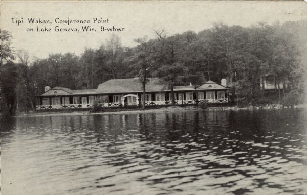 Photographic postcard view across lake towards a lakeside conference center nestled among the trees at the shoreline. Caption reads: "Tipi Wakan, Conference Point on Lake Geneva, Wis."