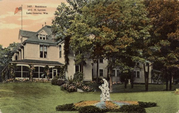 View of a large private home with a manicured lawn, statue, and flower beds. Caption reads: "Residence of C.H. Lytton, Lake Geneva, Wis."