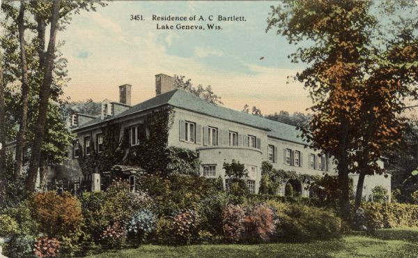 View of a large private home with flowery shrubs. Caption reads: "Residence of A.C [sic] Bartlett, Lake Geneva, Wis."