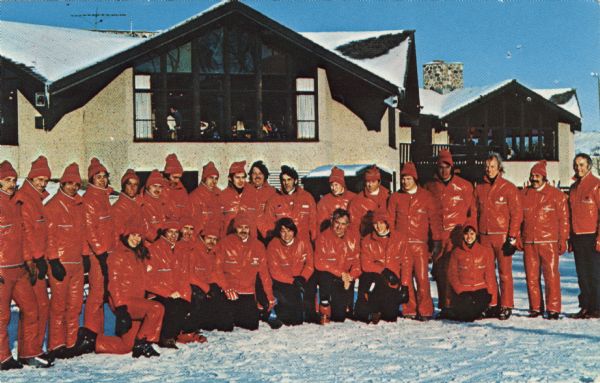 A group of ski instructors assembled for an outdoor group portrait.

Text on reverse reads: "Every year thousands of students learn to ski in lessons from these professional ski instructors. The Ray T. Stemper Ski Schools are operating under the direction of Jim Engel at Playboy Club and Majestic Hills in Lake Geneva, Wisconsin, and at Little Switzerland in Slinger, Wisconsin."