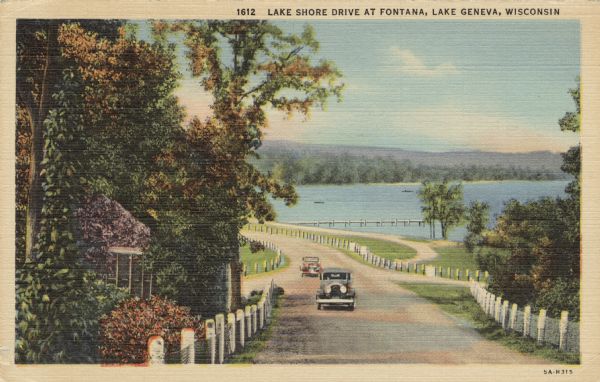 Hand-colored postcard view down lakeside road with two automobiles approaching. A long pier on the lake is in the background. Caption reads: "Lake Shore Drive at Fontana, Lake Geneva, Wisconsin."