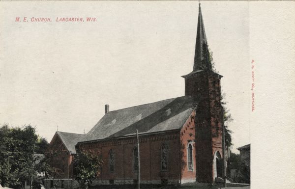 Hand-colored three-quarter view of the front and left side of a red brick church. Caption reads: "M.E. Church, Lancaster, Wis."