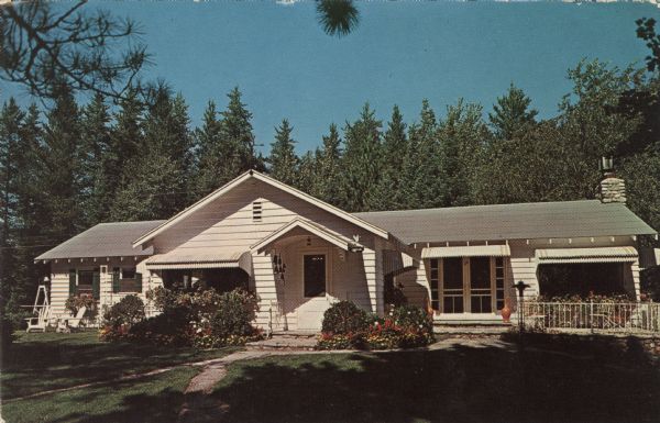 View across lawn toward the front of the lodge. Text on reverse reads, in part: "Sunrise Lodge on beautiful Lac Vieux Desert, Land O' Lakes." "Offering the finest in food. Brunch and dinner served daily. Featuring homemade breads, pastries and desserts."