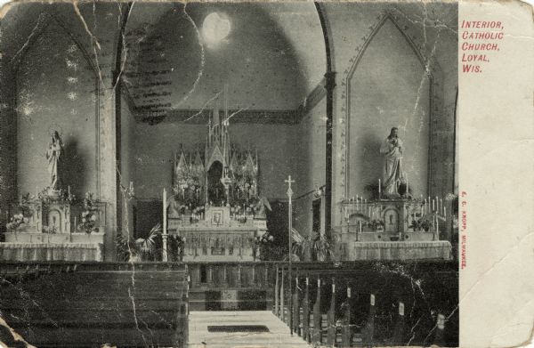View down aisle towards the altar of a Catholic Church. A statue of Mary is on the left, and one of Jesus is on the right. Caption reads: "Interior, Catholic Church, Loyal, Wis."