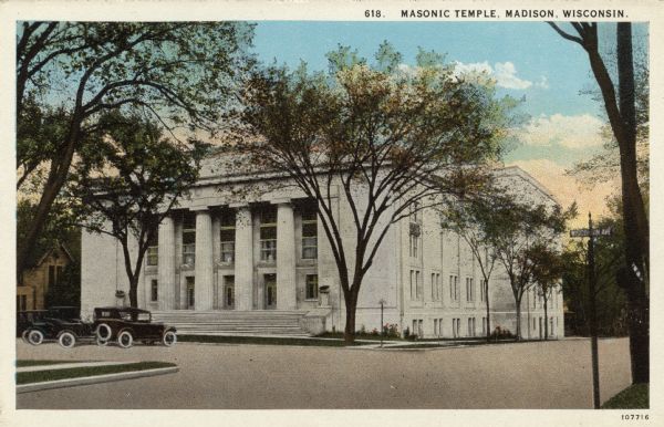 Hand-colored postcard view of the Masonic Temple located at E. Johnson Street and Wisconsin Avenue. Automobiles are parked at the curb. Caption Reads: "Masonic Temple, Madison, Wisconsin."
