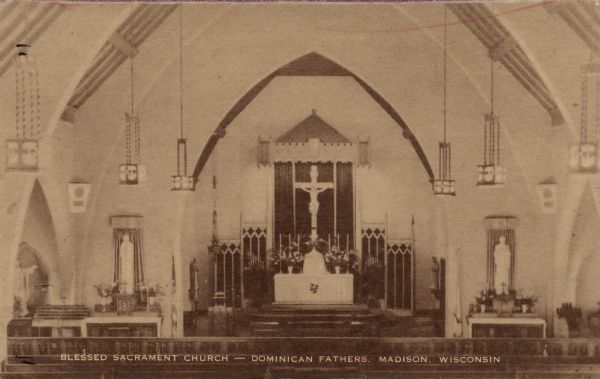 Elevated view towards the altar of a Catholic Church located at 2119 Rowley Avenue. The nave has Gothic arches. Caption Reads: "Blessed Sacrament Church &#8212; Dominican Fathers, Madison, Wisconsin."