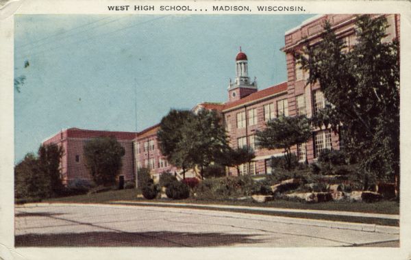 Exterior view of West High School. There is a bell tower over the entrance. Regent Street is in the foreground. Caption reads: "West High School . . . Madison, Wis."