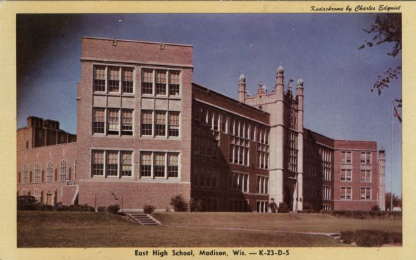 Exterior view of East High School, with a flagpole in front. Caption reads: "East High School, Madison, Wis."