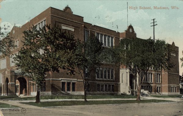 Exterior view of a three-story brick high school building. Caption reads: "High School, Madison, Wis."