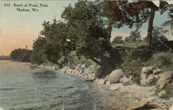 Hand-colored view of a small beach surrounded by boulders. Caption reads: "Beach at Picnic Point, Madison, Wis."