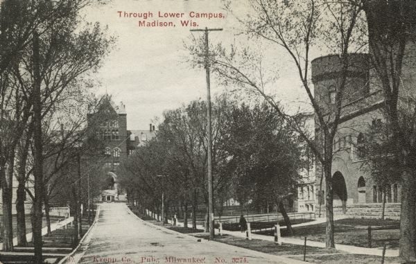 View down Langdon Street towards Science Hall on Park Street at the intersection. The armory (red gym) is on the right. The State Historical Society is behind trees on the left. Caption reads: "Through Lower Campus, Madison, Wis."