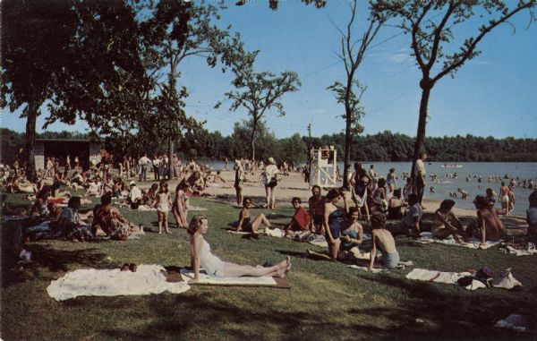 Color postcard view of a crowded bathing beach at Lake Wingra.