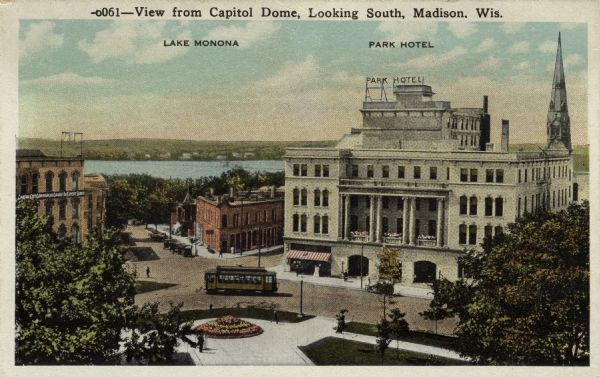 Elevated view of the southeast corner of Capitol Square. The Park Hotel is on the right and Lake Monona is in the background. An electric streetcar is going around the corner. Caption reads: "View from the Capitol Dome, Looking South, Madison, Wis."