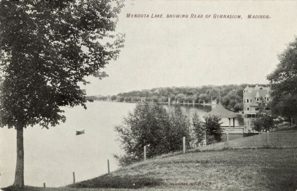 View from shoreline of the south shore of Lake Mendota. There is a pavilion on the shoreline, and a large boathouse in the distance.