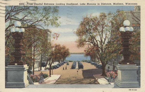 View of Monona Avenue from the southeast entrance of the Capitol. Automobiles are parked along the curbs and both sides of the median. Caption reads: "From Capitol Entrance Looking Southeast, Lake Monona in Distance, Madison, Wisconsin."