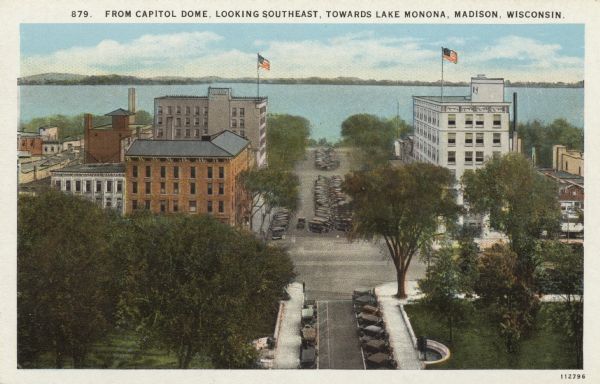 Elevated view of Monona Avenue from Capitol Square to Lake Monona. Automobiles are parked along the curbs and in the median. Caption reads: "From Capitol Dome, Looking Southeast, Towards Lake Monona, Madison, Wisconsin."