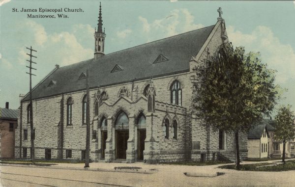 Three-quarter view from street towards a stone church. Streetcar tracks are running down the street. Caption reads: "St. James Episcopal Church, Manitowoc, Wis."
