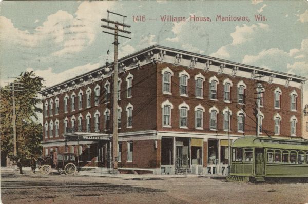 View from intersection towards a corner hotel in a central business district. A horse and carriage is at the left side entrance of the hotel, and a streetcar is on the street on the right. Caption reads: "Williams House, Manitowoc, Wis."