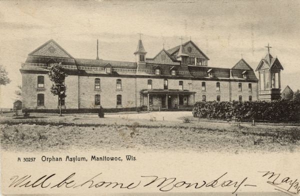 Exterior view of the orphan asylum. There are a number of crosses on the roof. Caption reads: "Orphan Asylum, Manitowoc, Wis."