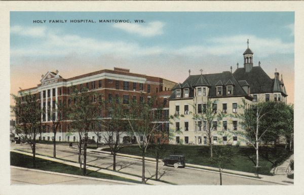 Elevated view of Holy Family Hospital. Automobiles are parked at the curb in front. There are crosses on the roof. Caption reads: "Holy Family Hospital, Manitowoc, Wis."