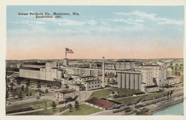Elevated view of the Cereal Products Co. plant, established 1847. Railroad tracks are along the shoreline in the foreground. Caption reads: "Cereal Products Co., Manitowoc, Wis. Established 1847."