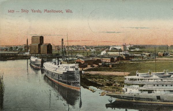 Elevated view of the shipyard along the Manitowoc River. Three ships are in the river. Caption reads: "Ship Yards, Manitowoc, Wis."