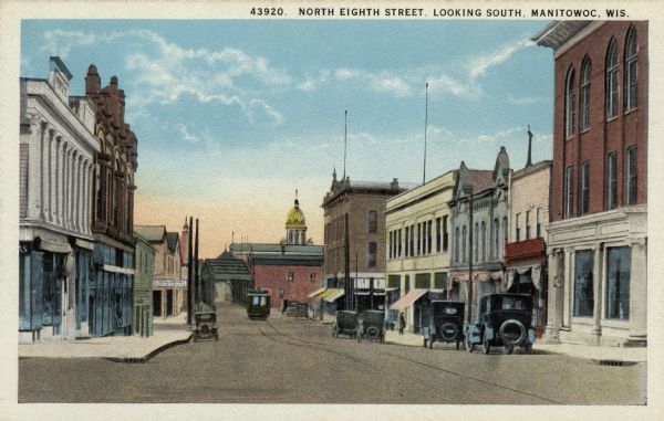 View of Eighth Street, facing south toward the bridge and the county courthouse. Caption reads: "North Eighth Street, Looking South, Manitowoc, Wis."