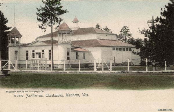 Exterior view of the Chautauqua auditorium and the surrounding fence. Caption reads: "Auditorium, Chautauqua, Marinette, Wis."