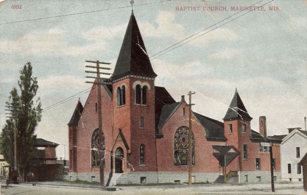 Exterior view of a church with a bell tower in the corner, and large, stained-glass windows. Caption reads: "Baptist Church, Marinette, Wis."
