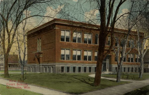 Exterior view from street towards the school on a street corner. A bicycle is parked near the door. Caption reads: "New Ella Court School, Marinette, Wis."