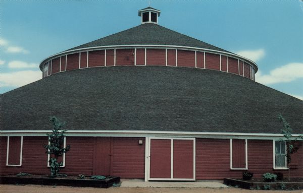 Color postcard of a round barn, 150 ft. in diameter, 50 feet high, built in 1917.