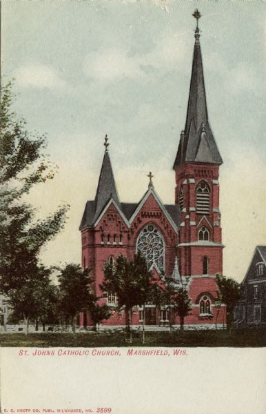 Exterior view of St. John's Catholic Church, which has two steeples and a rose window. Caption reads: "St. John's Catholic Church, Marshfield, Wis."