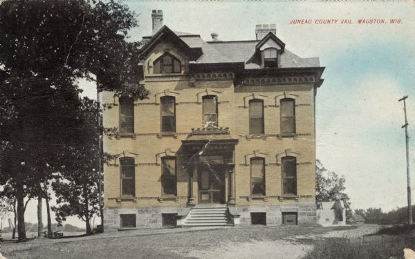 Exterior view of the jail. Caption reads: "Juneau County Jail, Mauston, Wis."