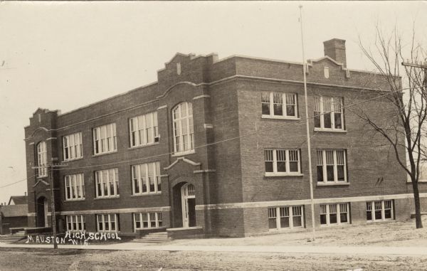 Exterior view of the high school. Two entrances are in front. Caption reads: "High School, Mauston, Wis."