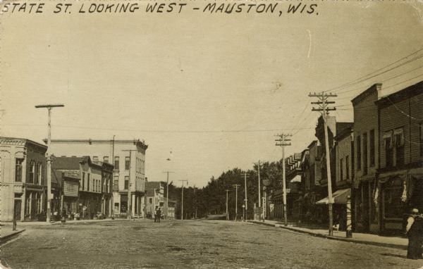 View down street in the central business district. Caption reads: "State St. Looking West &#8212; Mauston, Wis."