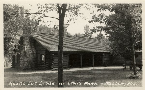 Exterior view of a log structure with a stone chimney at Copper Falls State Park.