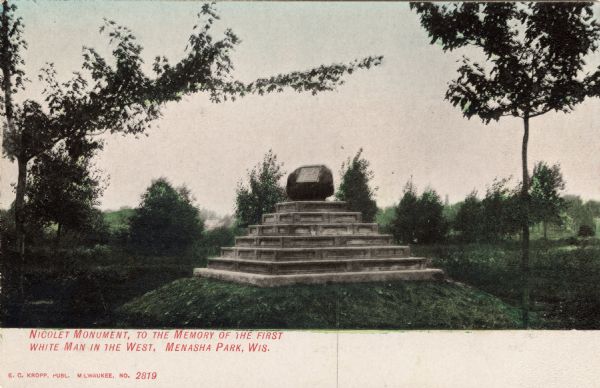 View of a boulder on a stepped pedestal with a plaque dedicated to Jean Nicolet. Caption reads: "Nicolet Monument, to the Memory of the First White Man in the West, Menasha Park, Wis."