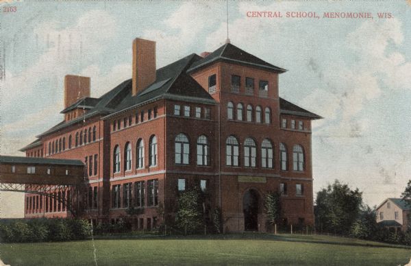 The high school building. A pedestrian bridge is on the left side of the building. Caption reads: "Central School, Menomonie, Wis."